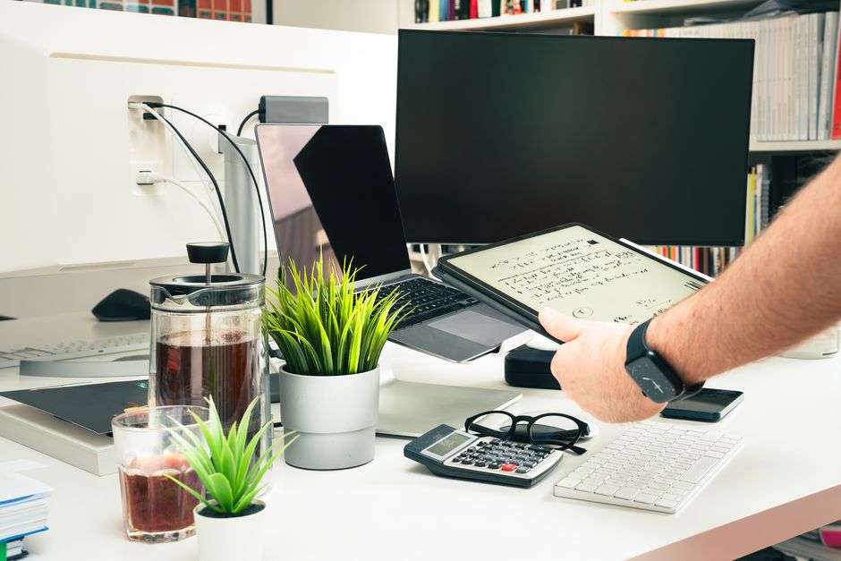 Um ambiente de escritório contemporâneo com tecnologia e vegetação sobre a mesa.